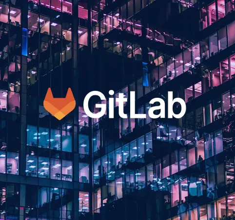 Logo de GitLab sobre un fondo de edificio iluminado por la noche.