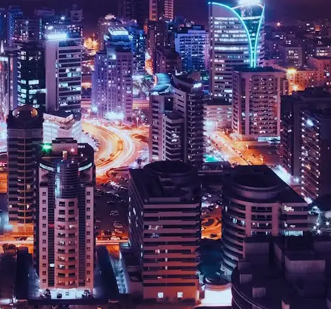 Vista nocturna de una ciudad moderna iluminada con luces vibrantes